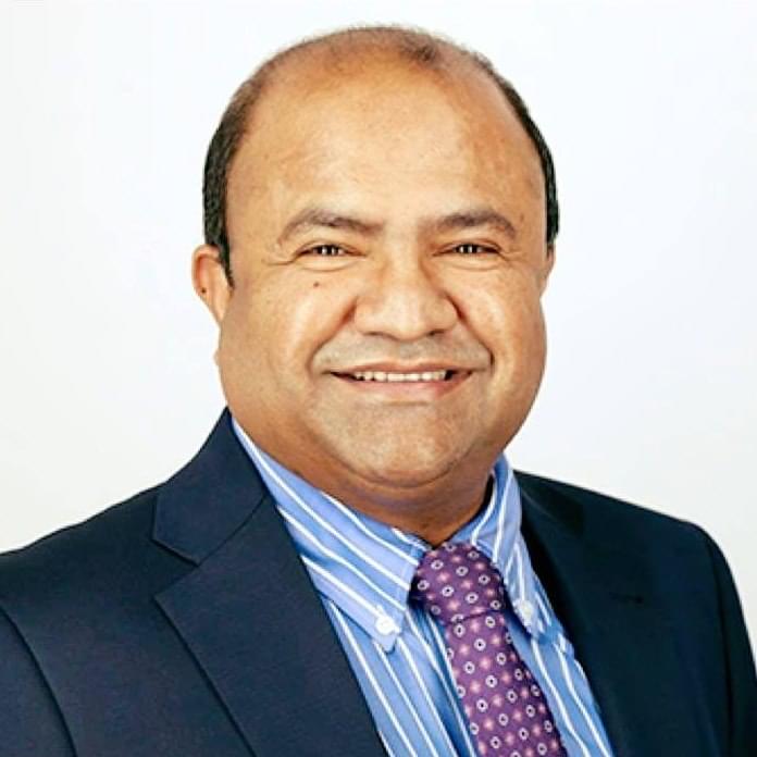 Dr Mohammad Masud, wearing a navy suit and striped shirt