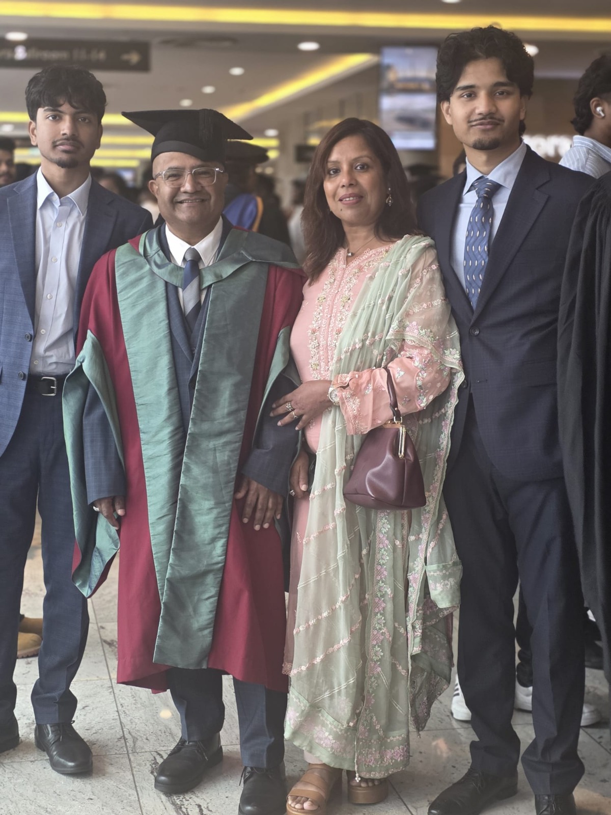 Dr Mohammad Masud in academic gown and mortarboard, photographed with his family at his doctorate graduation